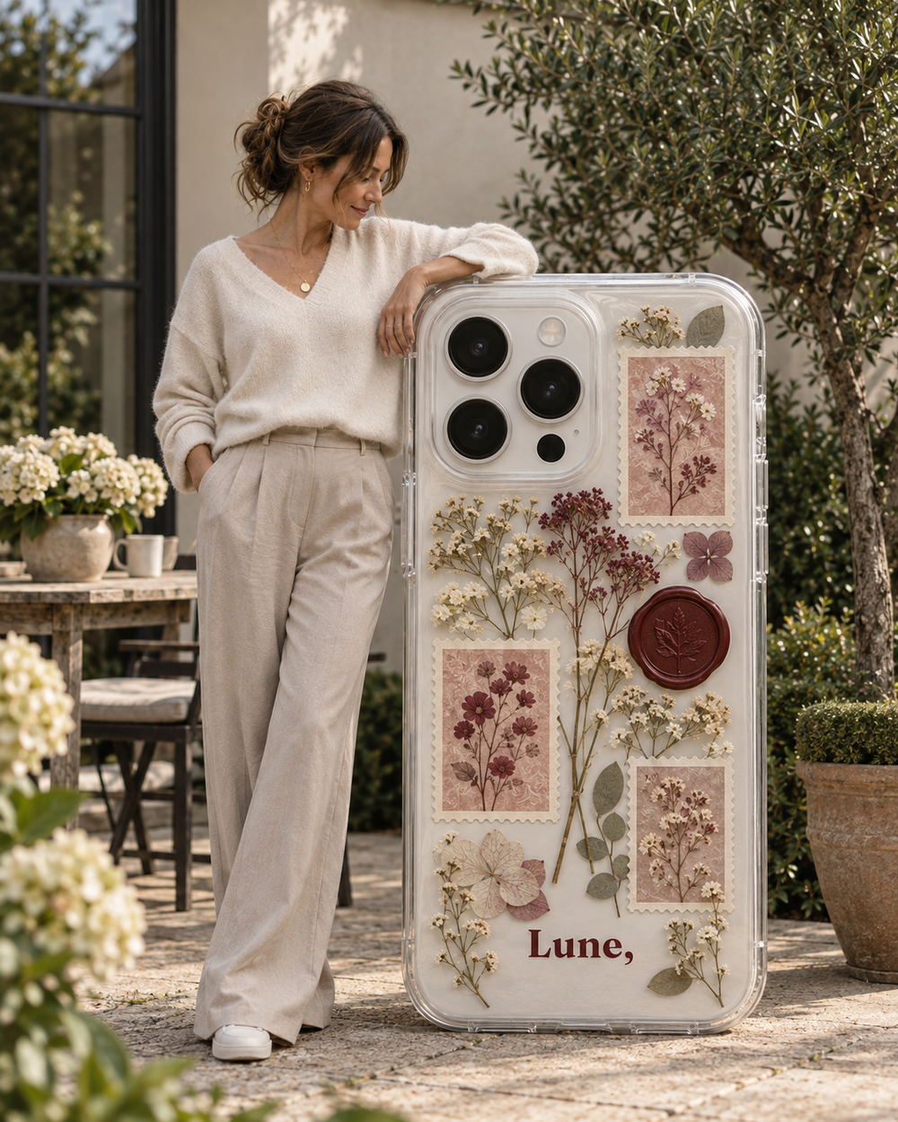 Classy-stijl: hoesje met postzegels, bloemen en een lakzegel naast een vrouw in het wit