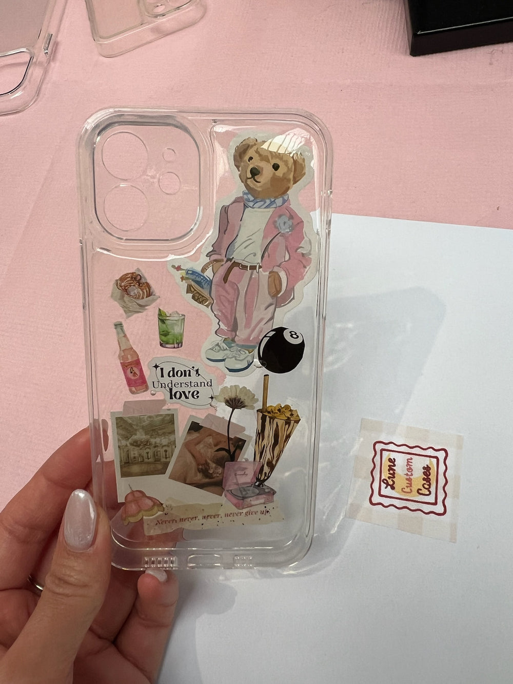 Hoesje met een teddybeer in een roze pak, postzegels en kleine plaatjes