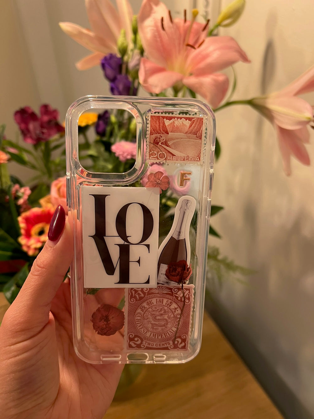 Hoesje met een LOVE-plaatje en rode postzegels voor een boeket bloemen